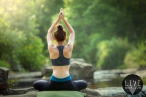 YOGA Young woman  practicing yoga and relaxing  at waterfall and